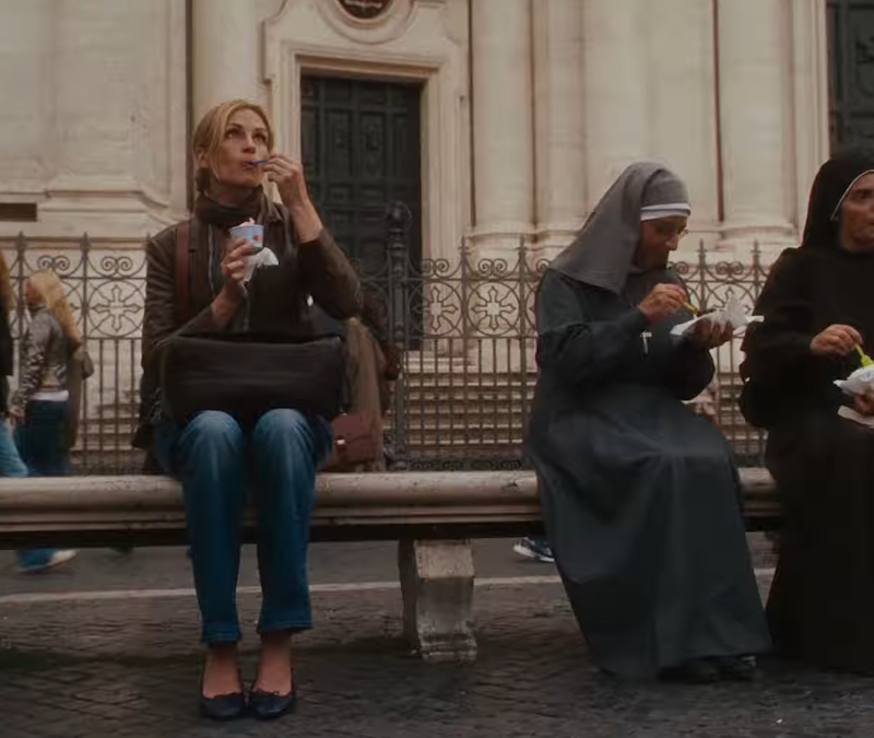 alt="Julia Roberts eats ice cream in Italy while sitting next to nuns in Eat Pray Love"