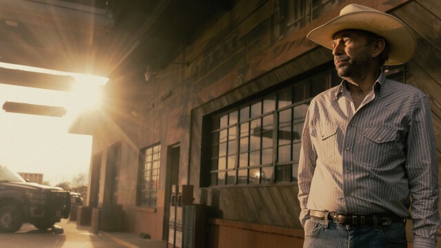 alt="Billy Bob Thornton as Tommy Norris standing outside a West Texas bar at sunset in Landman"