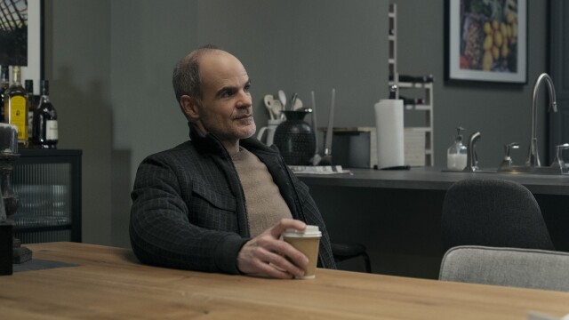 Michael Kelly as Mike November in Jack Ryan sitting at a table drinking coffee